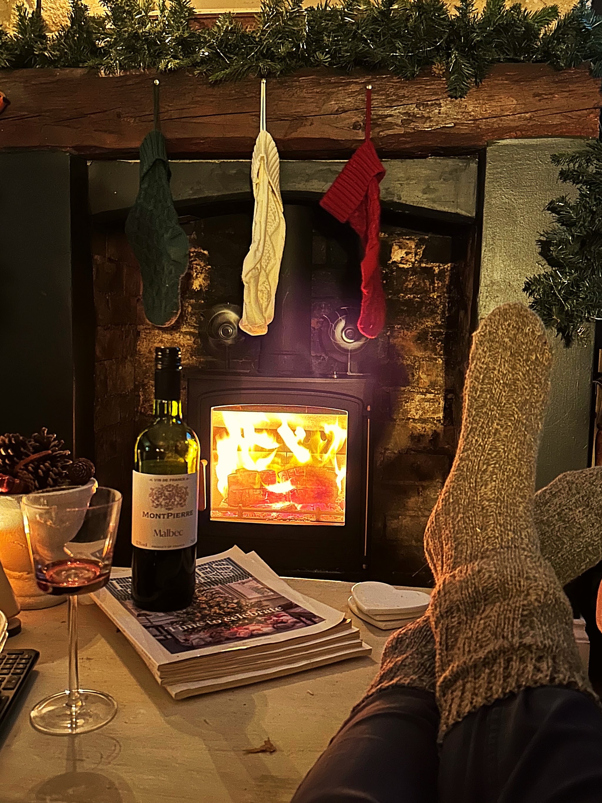 A lit stove under a beam hung with Christmas stockings