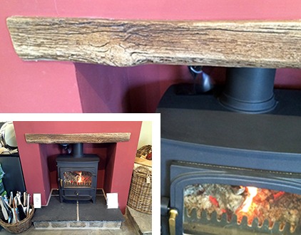 A wood effect beam over a stove in a red fireplace recess